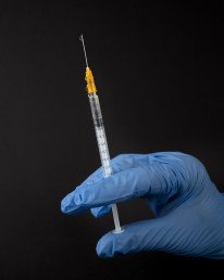 person in white pants and white shirt holding clear glass tube