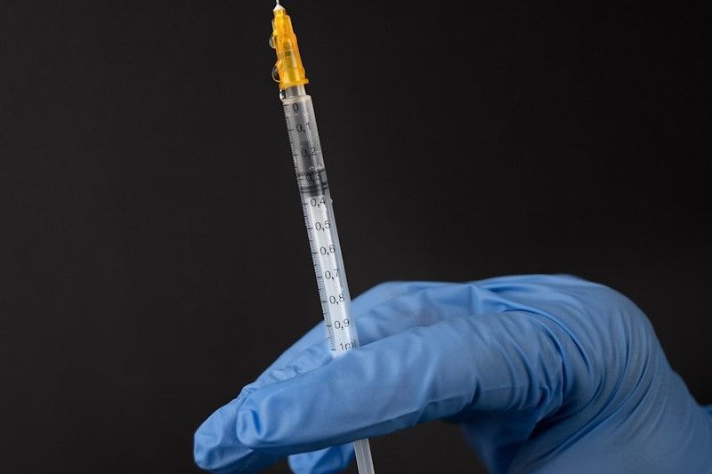 person in white pants and white shirt holding clear glass tube